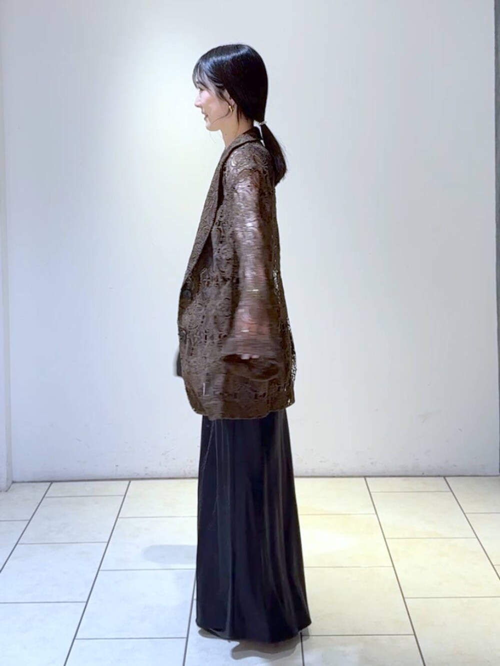 ブルー系のタンクトップ、ブラック系のスカート、ブラック系のパンプスを着用したレディースの春コーディネートの5枚目の写真