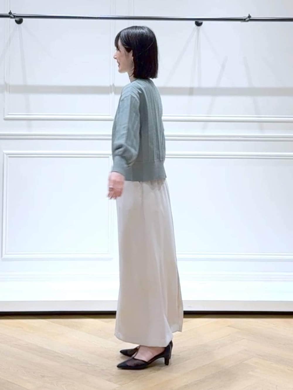 グリーン系のカーディガン/ボレロ、ブラック系のパンプス、ブラウン系のショルダーバッグを着用したレディースの春コーディネートの5枚目の写真