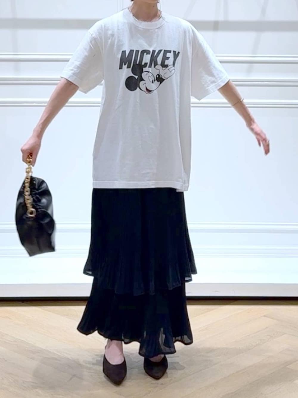 ブラック系のスカート、ホワイト系のTシャツ/カットソー、ブラウン系のパンプスを着用したレディースの秋コーディネートの2枚目の写真