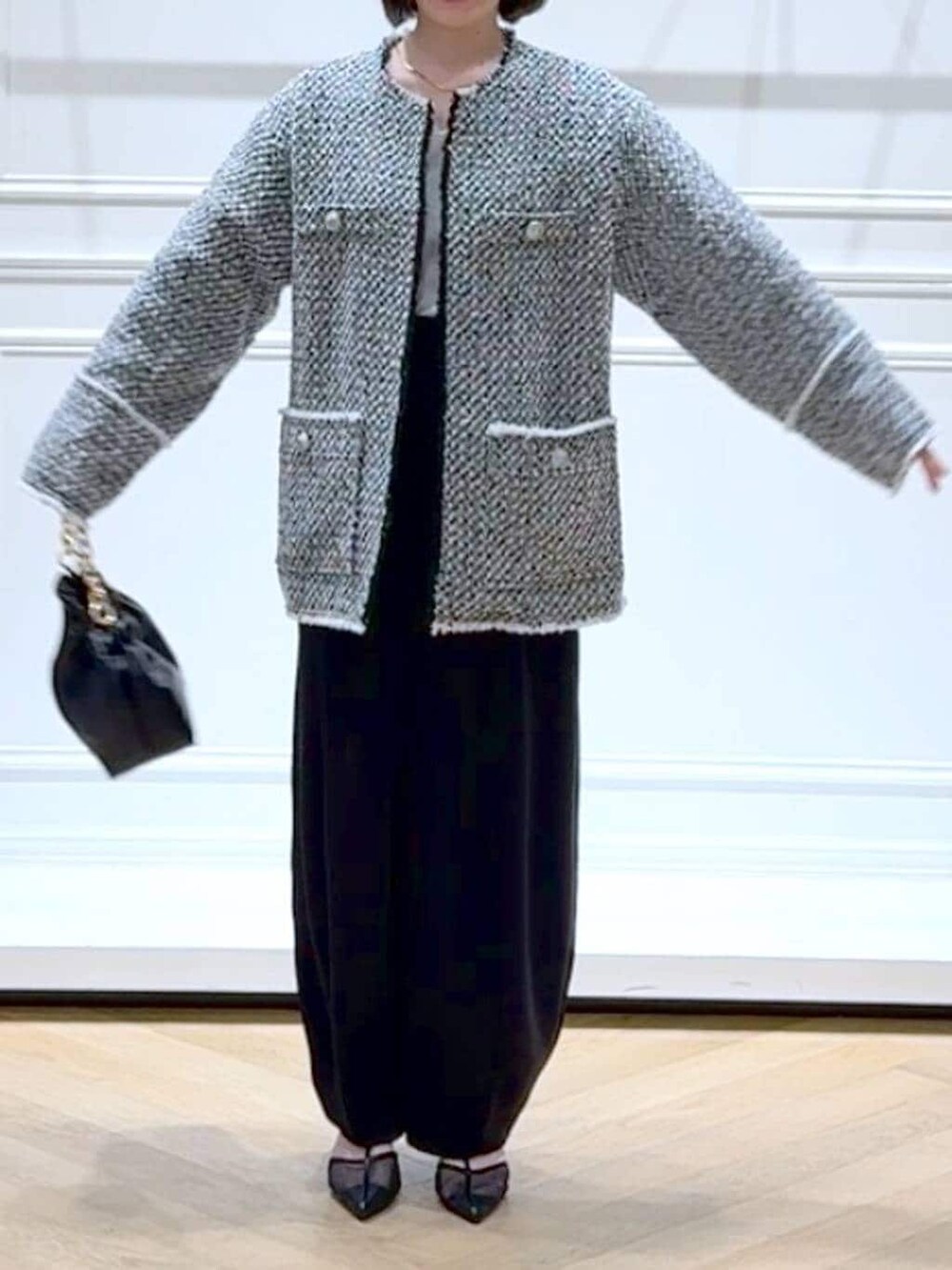 ブラック系のショルダーバッグ、ブラック系のスラックス、ブラック系のノーカラージャケットを着用したレディースの春コーディネートの2枚目の写真