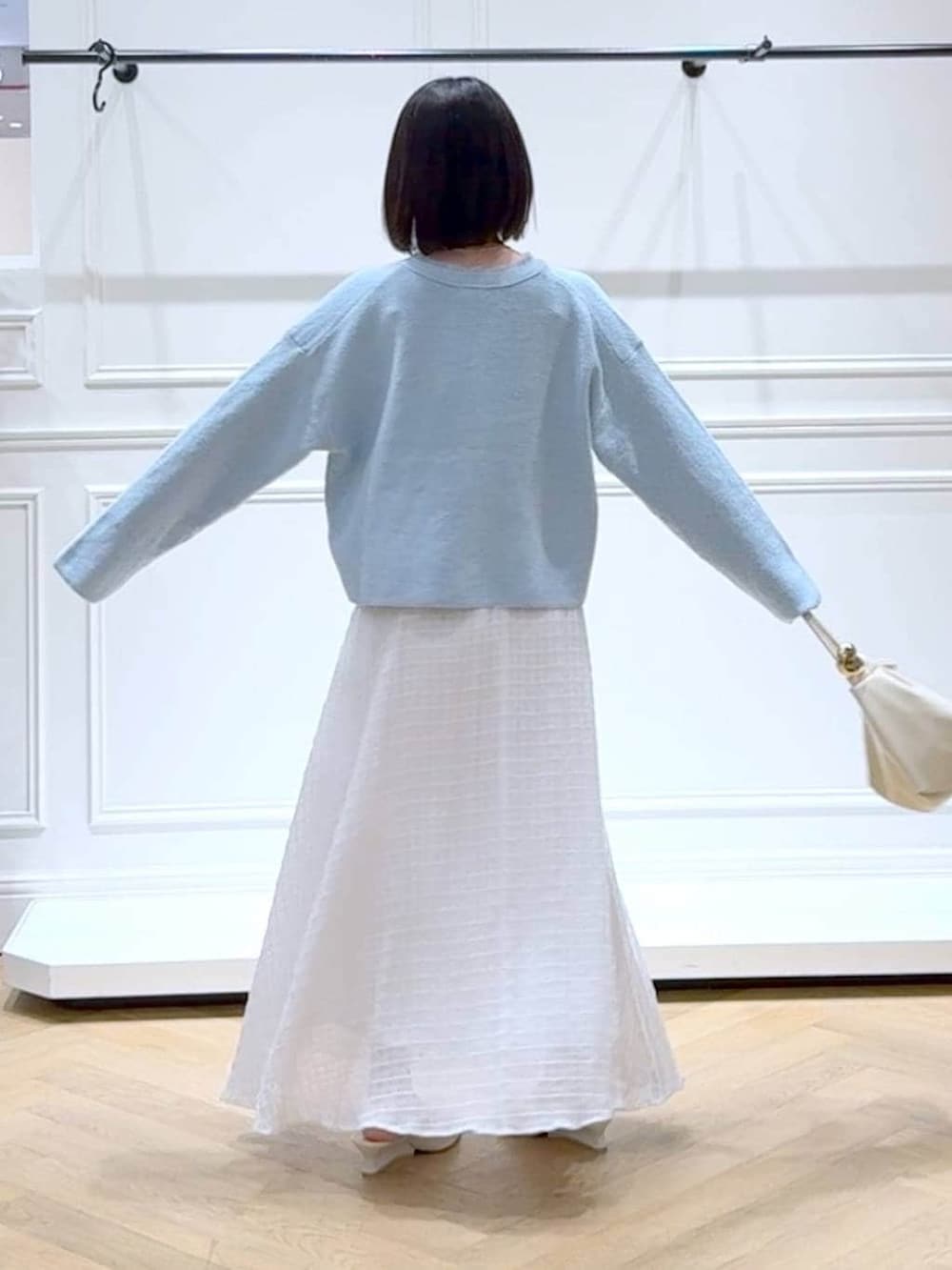 ブルー系のカーディガン/ボレロ、ホワイト系のサンダル、ホワイト系のスカートを着用したレディースの春コーディネートの4枚目の写真