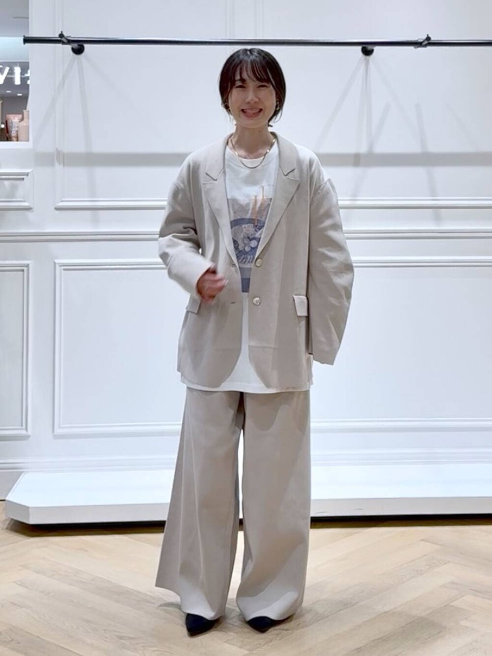 ベージュ系のパンツドレス、ブラック系のブーツ、ホワイト系のTシャツ/カットソーを着用したレディースの秋コーディネートの6枚目の写真