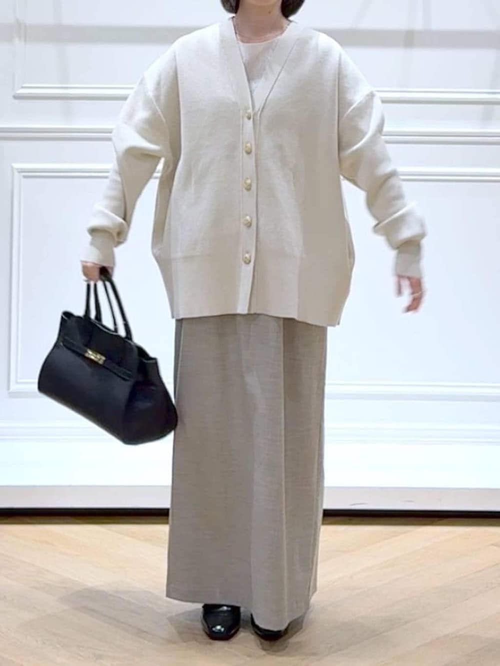 ブラック系のローファー、ホワイト系のカーディガン/ボレロ、ホワイト系のTシャツ/カットソーを着用したレディースの春コーディネートの2枚目の写真