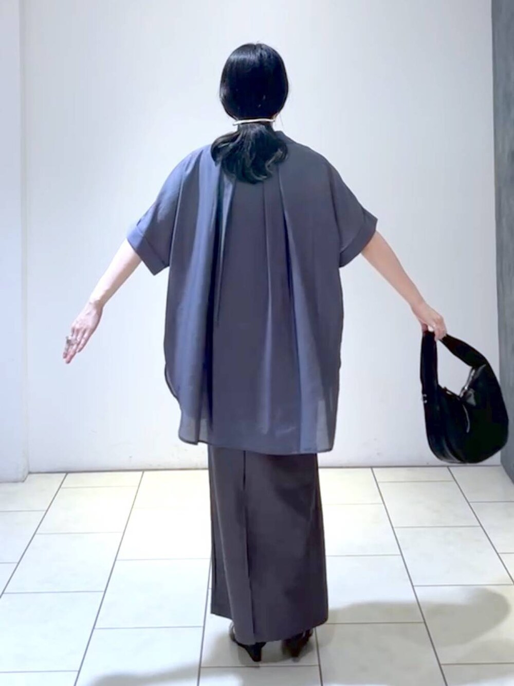 ブラック系のサンダル、ブラック系のハンドバッグ、ブラック系のタンクトップを着用したレディースの夏コーディネートの4枚目の写真