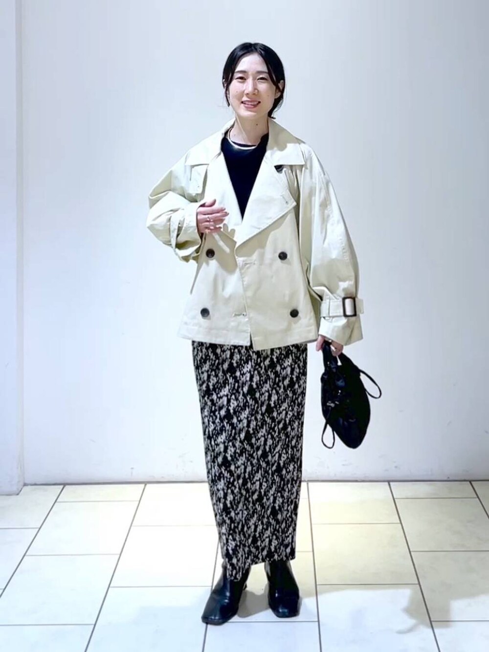 ブルー系のニット/セーター、グレー系のスカート、ブラック系のブーツを着用したレディースの春コーディネートの6枚目の写真