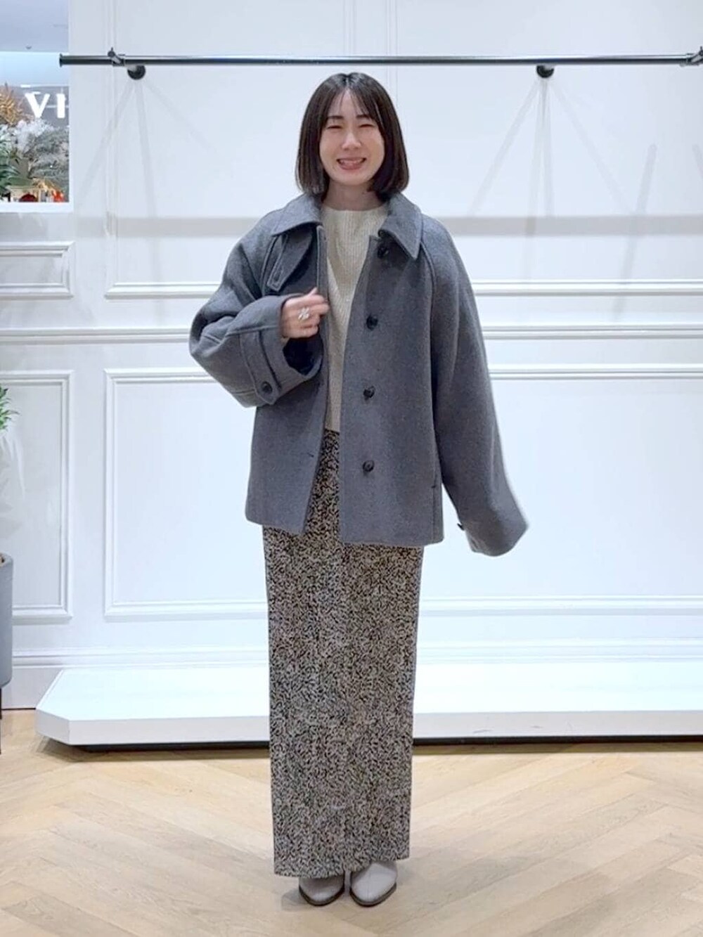 ベージュ系のブーツ、ホワイト系のニット/セーター、ベージュ系のスカートを着用したレディースの冬コーディネートの6枚目の写真