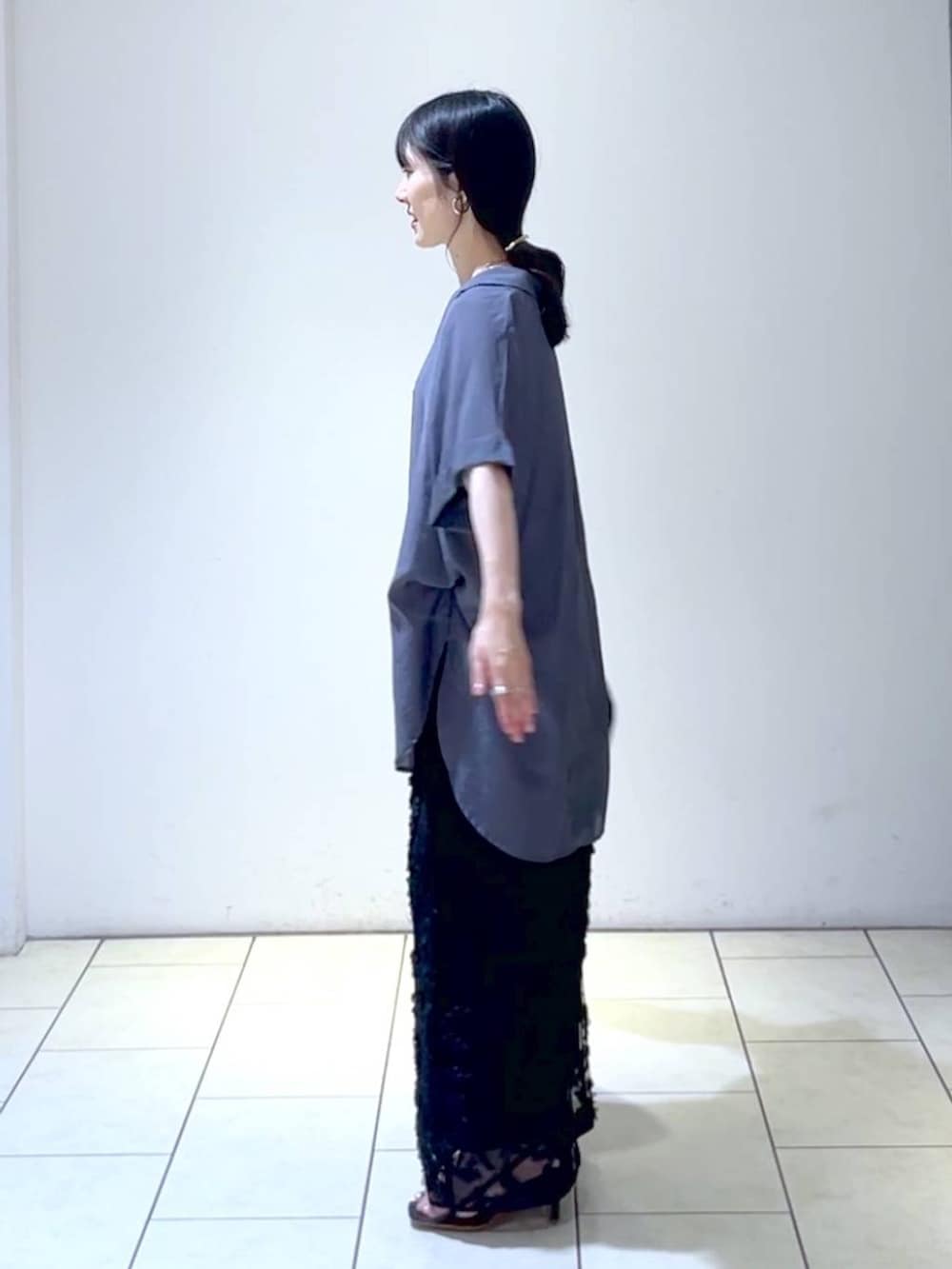 ブラック系のハンドバッグ、グレー系のシャツ/ブラウス、ブラック系のスカートを着用したレディースの夏コーディネートの5枚目の写真