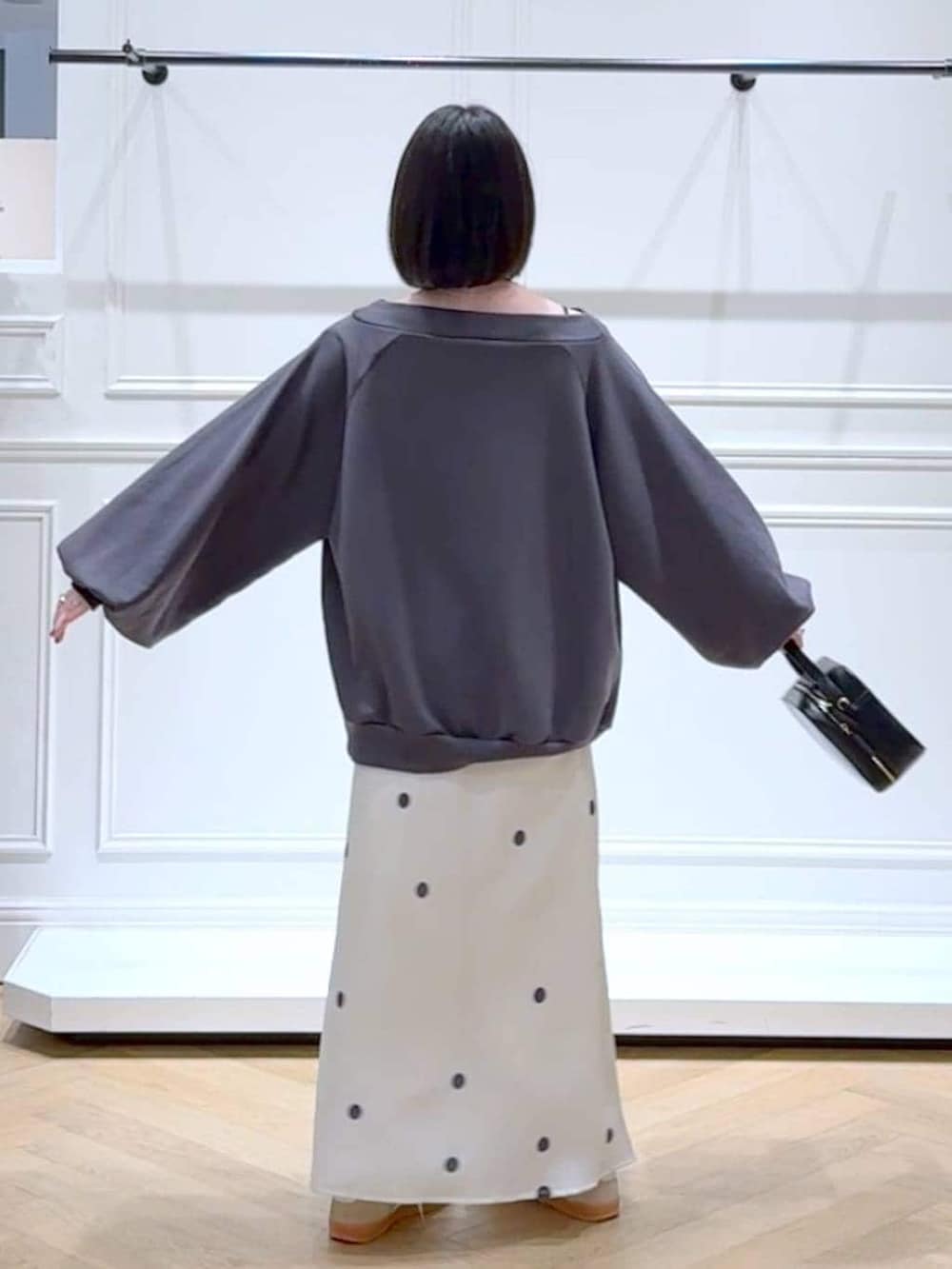 ベージュ系のスニーカー、グレー系のスウェット、ホワイト系のスカートを着用したレディースの春コーディネートの4枚目の写真