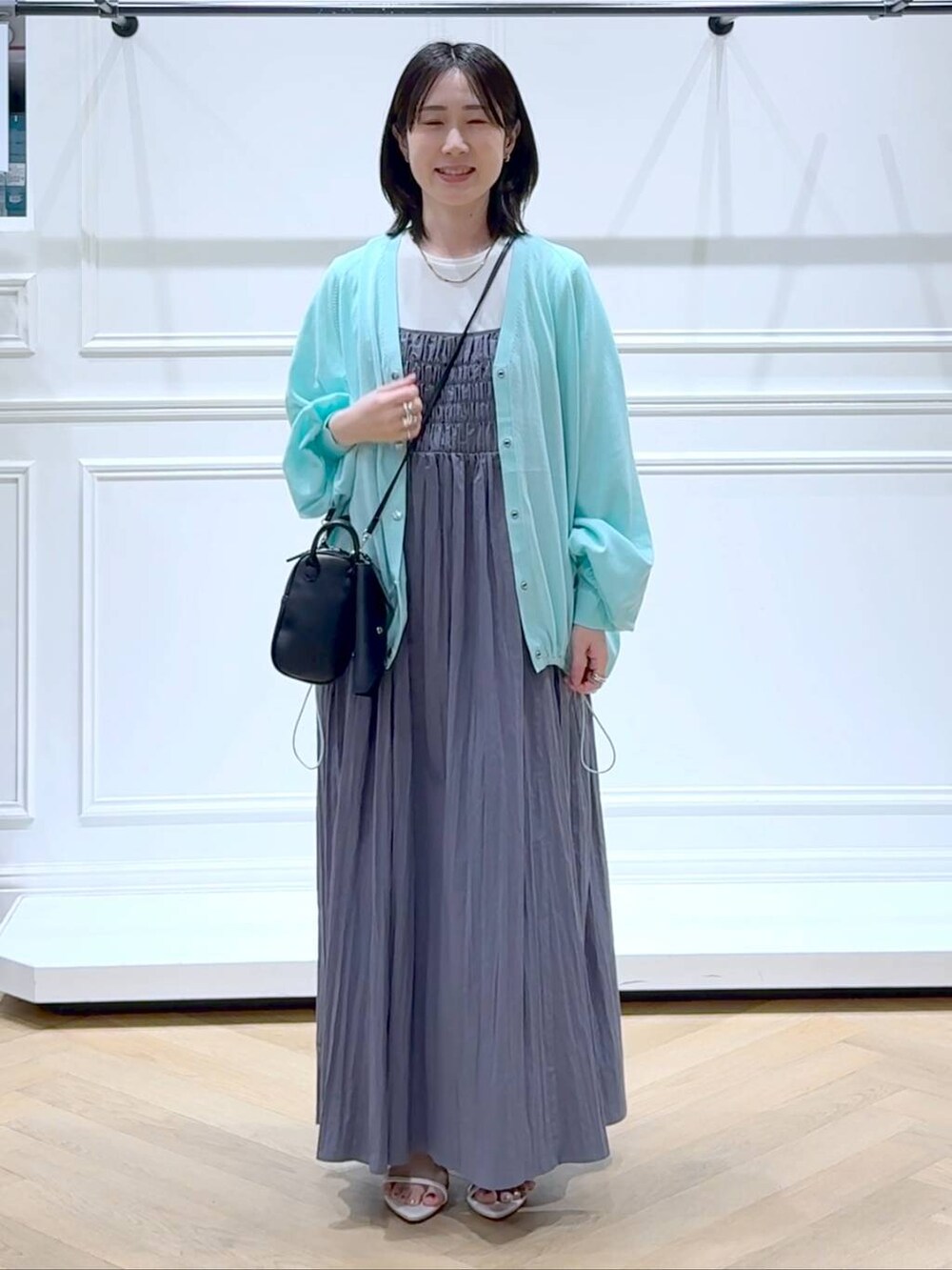 グリーン系のカーディガン/ボレロ、ホワイト系のサンダル、ホワイト系のTシャツ/カットソーを着用したレディースの夏コーディネートの6枚目の写真