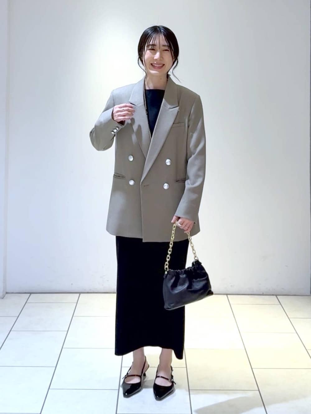 ホワイト系のワンピース、ブラック系のパンプス、グレー系のテーラードジャケットを着用したレディースの冬コーディネートの7枚目の写真