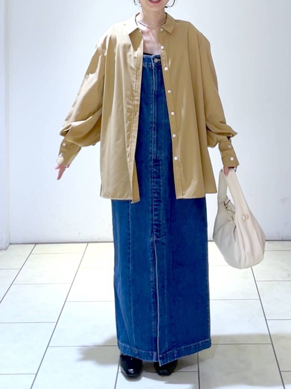 ブラウン系のシャツ/ブラウス、ブルー系のジャンパースカート、ブラック系のローファーを着用したレディースの秋コーディネートの2枚目の写真