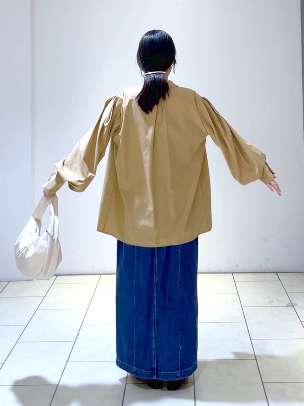 ブラウン系のシャツ/ブラウス、ブルー系のジャンパースカート、ブラック系のローファーを着用したレディースの秋コーディネートの4枚目の写真