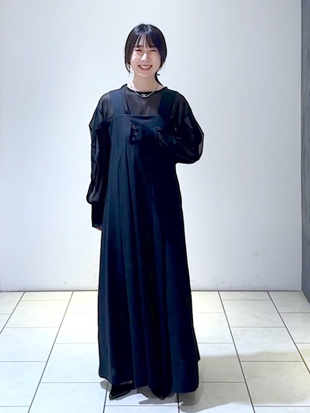 ブラック系のジャンパースカート、ブラック系のシャツ/ブラウス、ブラック系のパンプスを着用したレディースの秋コーディネートの6枚目の写真