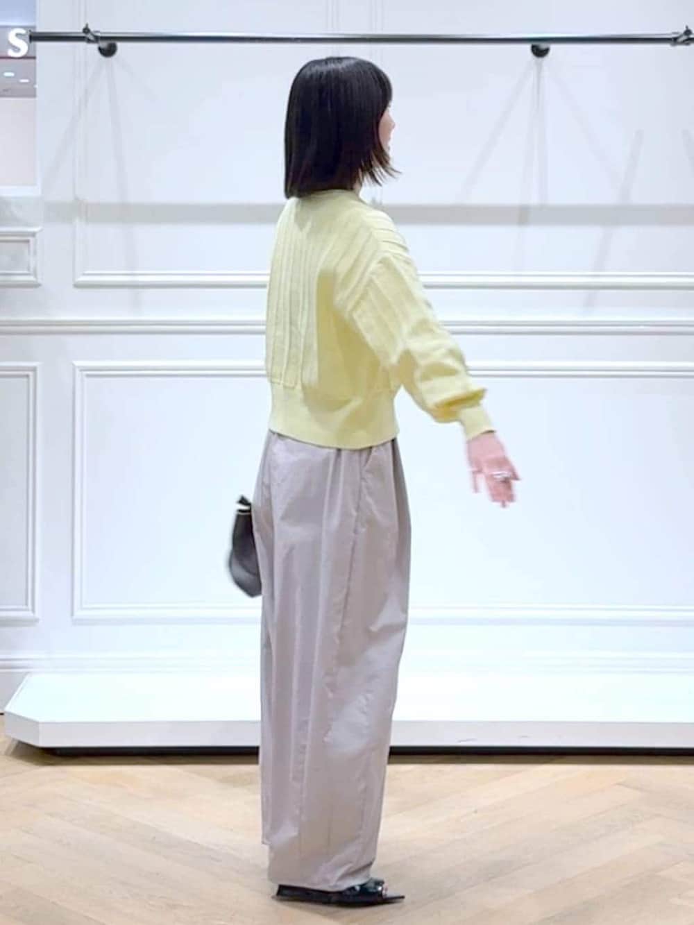 イエロー系のカーディガン/ボレロ、ブラウン系のショルダーバッグ、ブラック系のサンダルを着用したレディースの春コーディネートの3枚目の写真