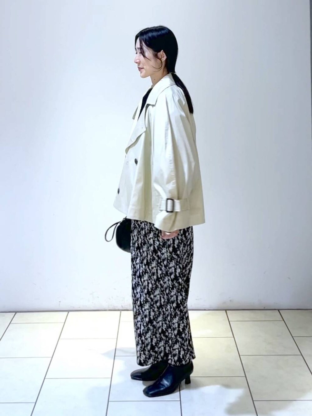 ブルー系のニット/セーター、グレー系のスカート、ブラック系のブーツを着用したレディースの春コーディネートの5枚目の写真