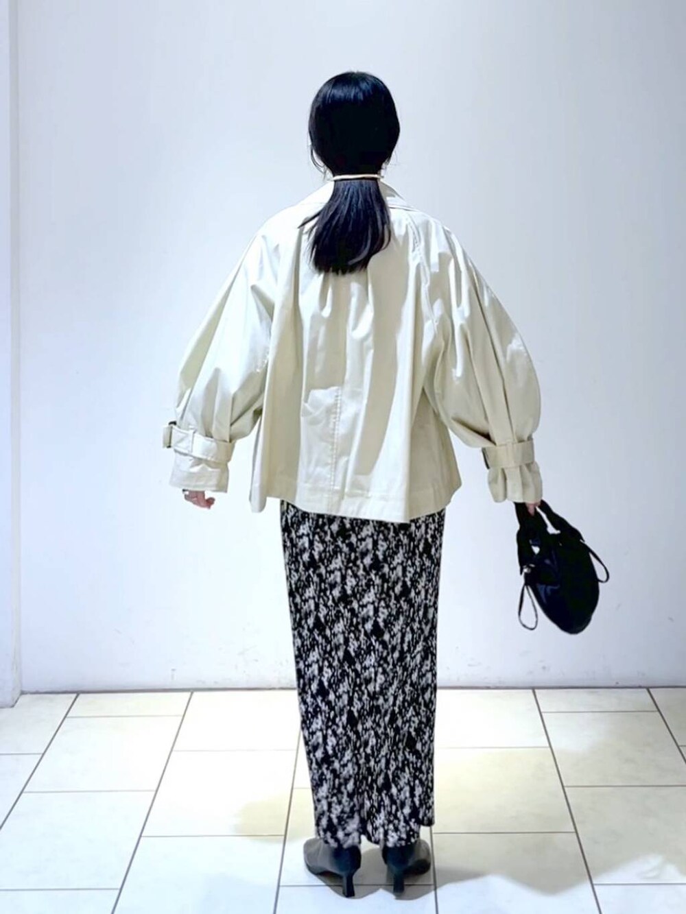 ブルー系のニット/セーター、グレー系のスカート、ブラック系のブーツを着用したレディースの春コーディネートの4枚目の写真