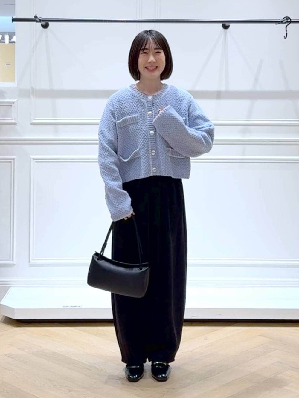 ブラック系のローファー、ブラック系のスラックス、ブルー系のカーディガン/ボレロを着用したレディースの冬コーディネートの6枚目の写真