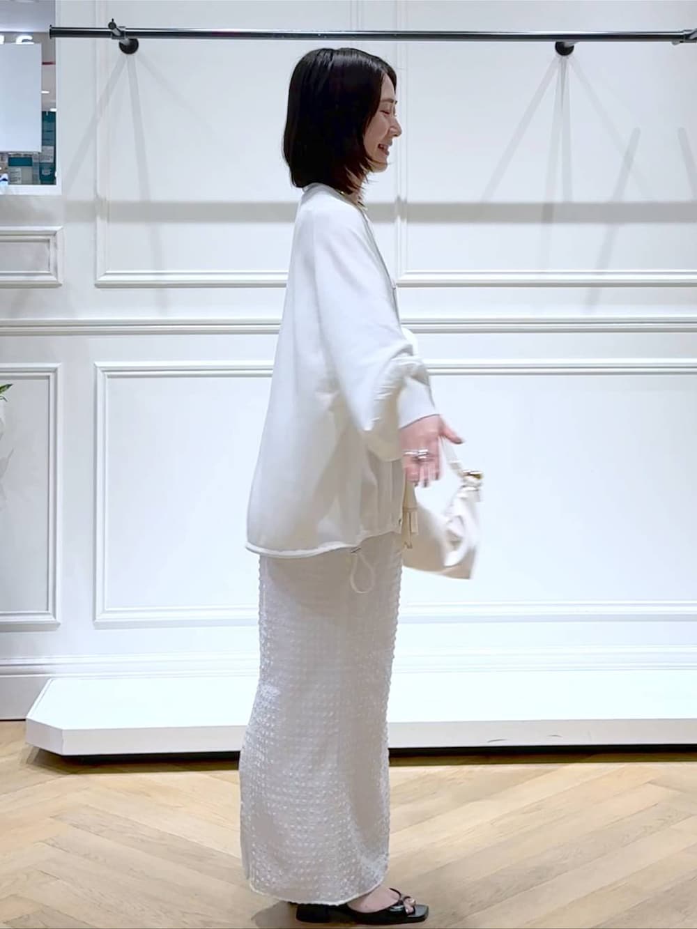 ホワイト系のカーディガン/ボレロ、ホワイト系のショルダーバッグ、ブラック系のパンプスを着用したレディースの夏コーディネートの3枚目の写真