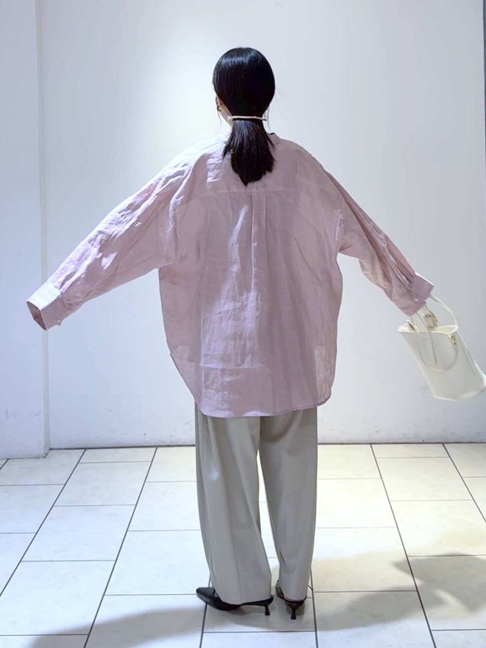 グレー系のタンクトップ、ホワイト系のショルダーバッグ、ブラック系のパンプスを着用したレディースの春コーディネートの4枚目の写真