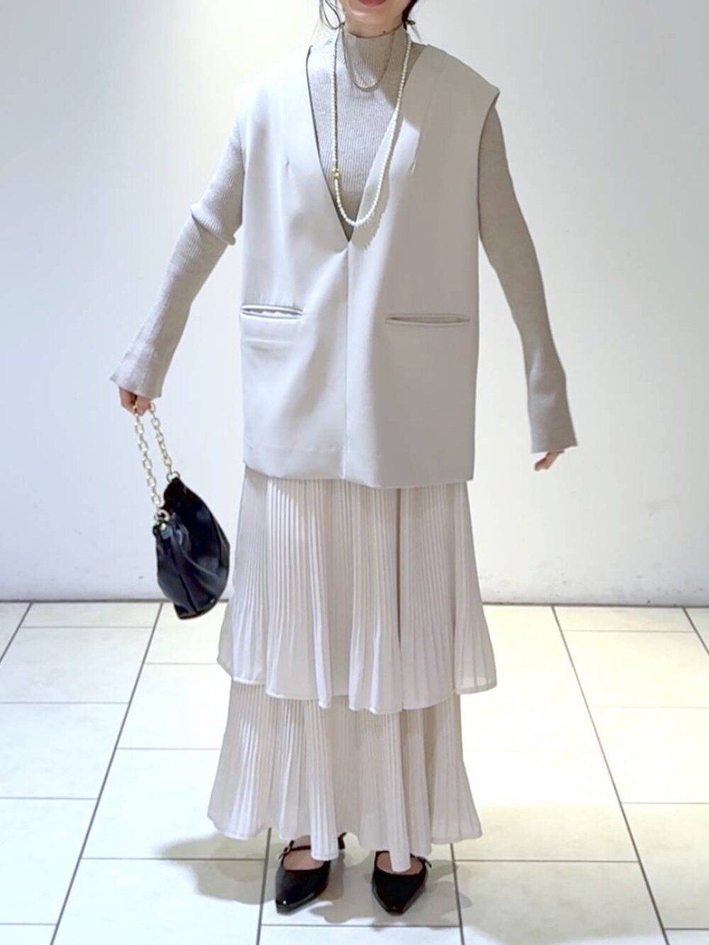 ホワイト系のスカート、ベージュ系のスーツセット、ホワイト系のニット/セーターを着用したレディースの冬コーディネートの2枚目の写真