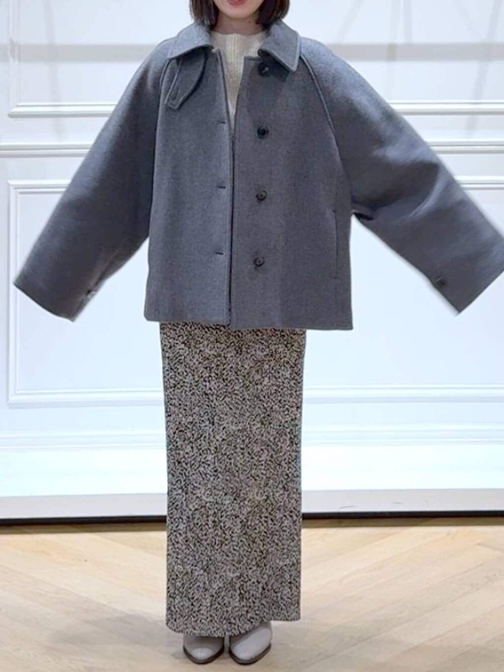 ベージュ系のブーツ、ホワイト系のニット/セーター、ベージュ系のスカートを着用したレディースの冬コーディネートの2枚目の写真