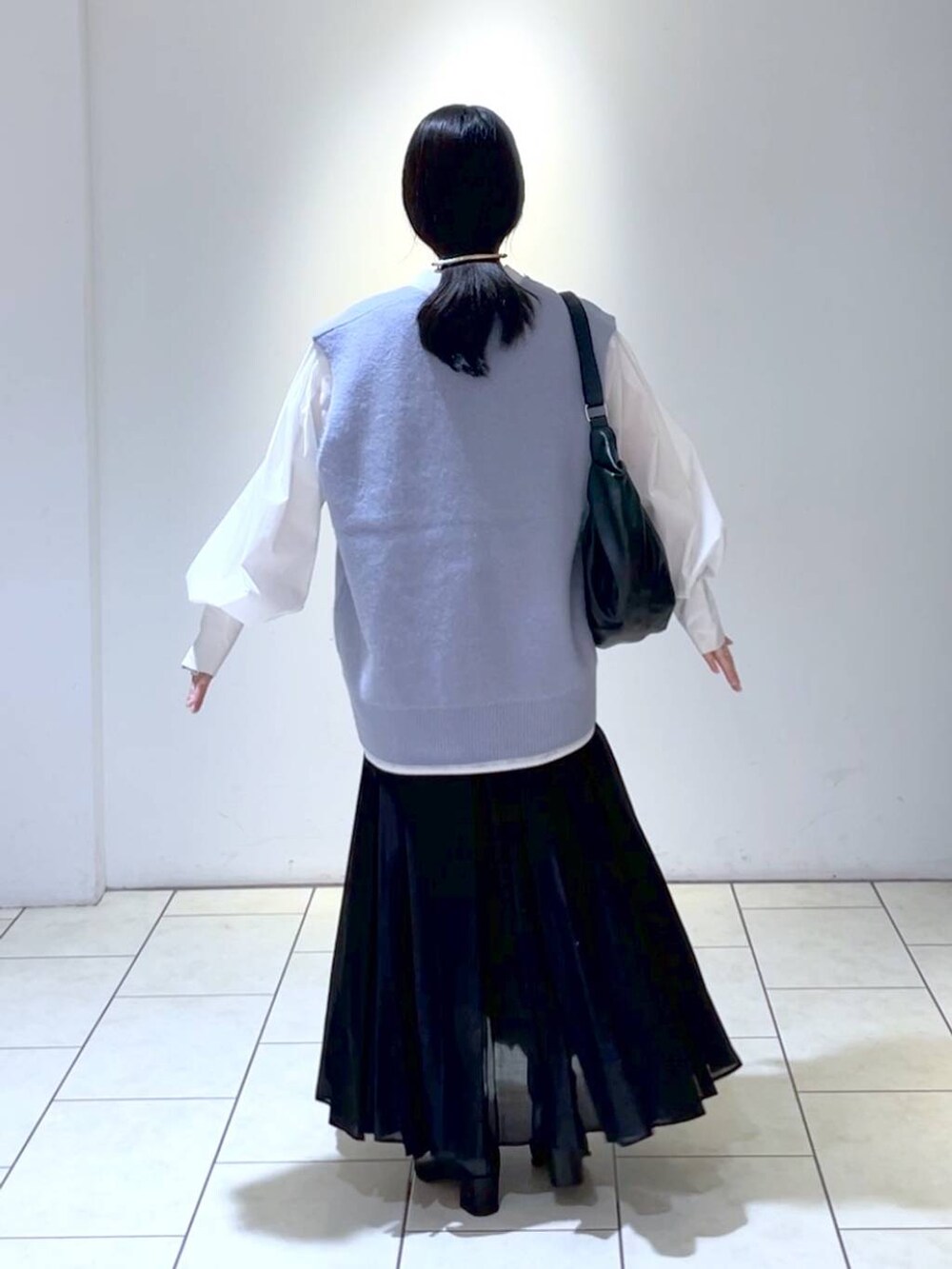 ホワイト系のシャツ/ブラウス、ブラック系のブーツ、ブラック系のスカートを着用したレディースの秋コーディネートの4枚目の写真