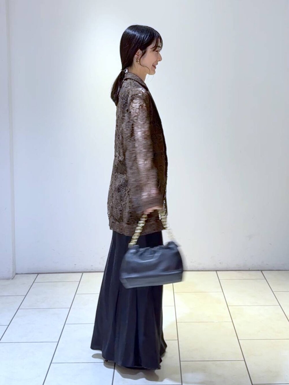 ブルー系のタンクトップ、ブラック系のスカート、ブラック系のパンプスを着用したレディースの春コーディネートの3枚目の写真