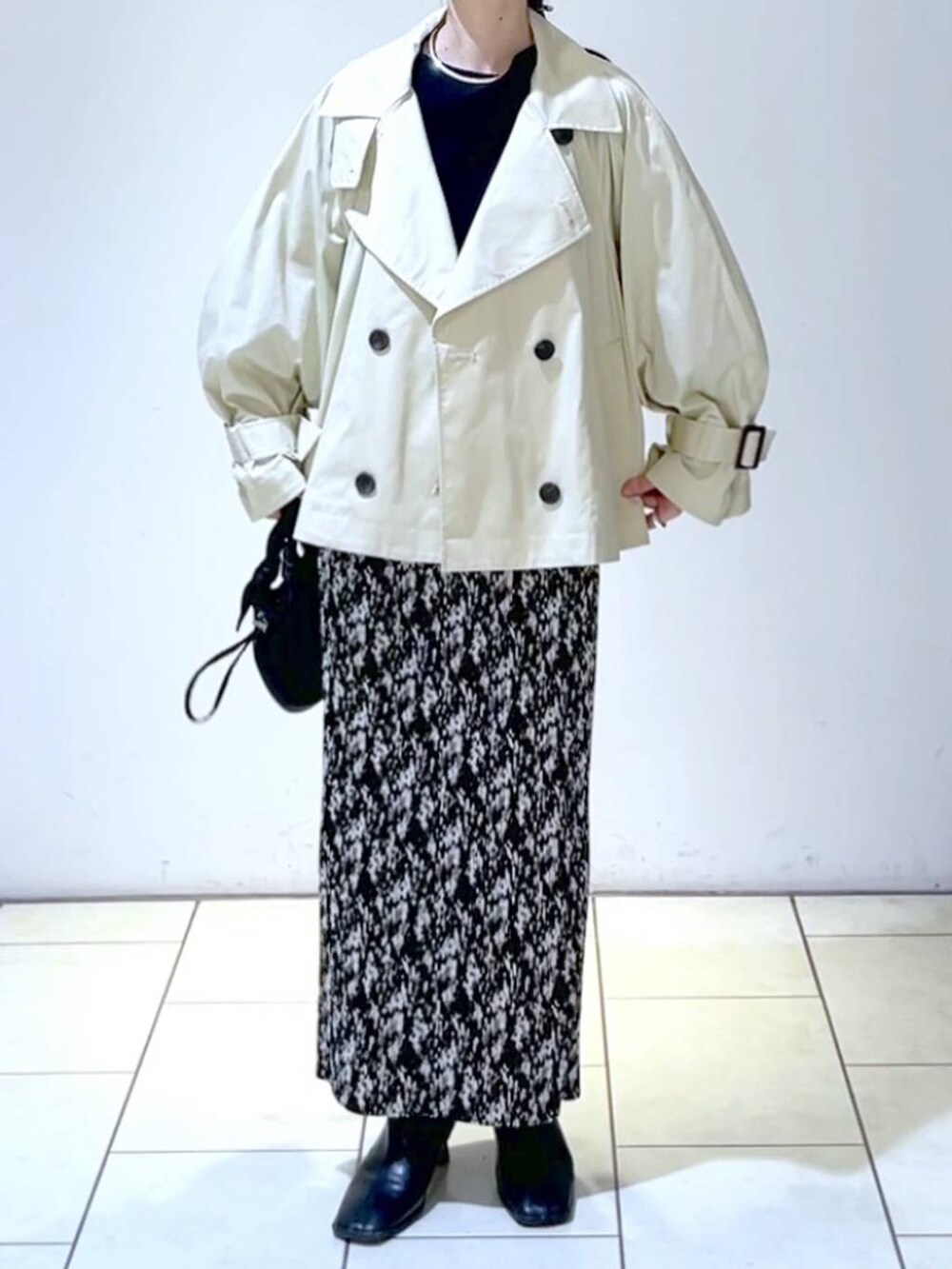 ブルー系のニット/セーター、グレー系のスカート、ブラック系のブーツを着用したレディースの春コーディネートの2枚目の写真