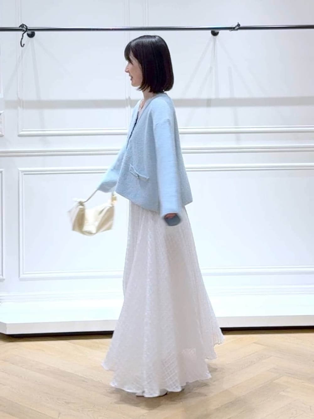 ブルー系のカーディガン/ボレロ、ホワイト系のサンダル、ホワイト系のスカートを着用したレディースの春コーディネートの5枚目の写真