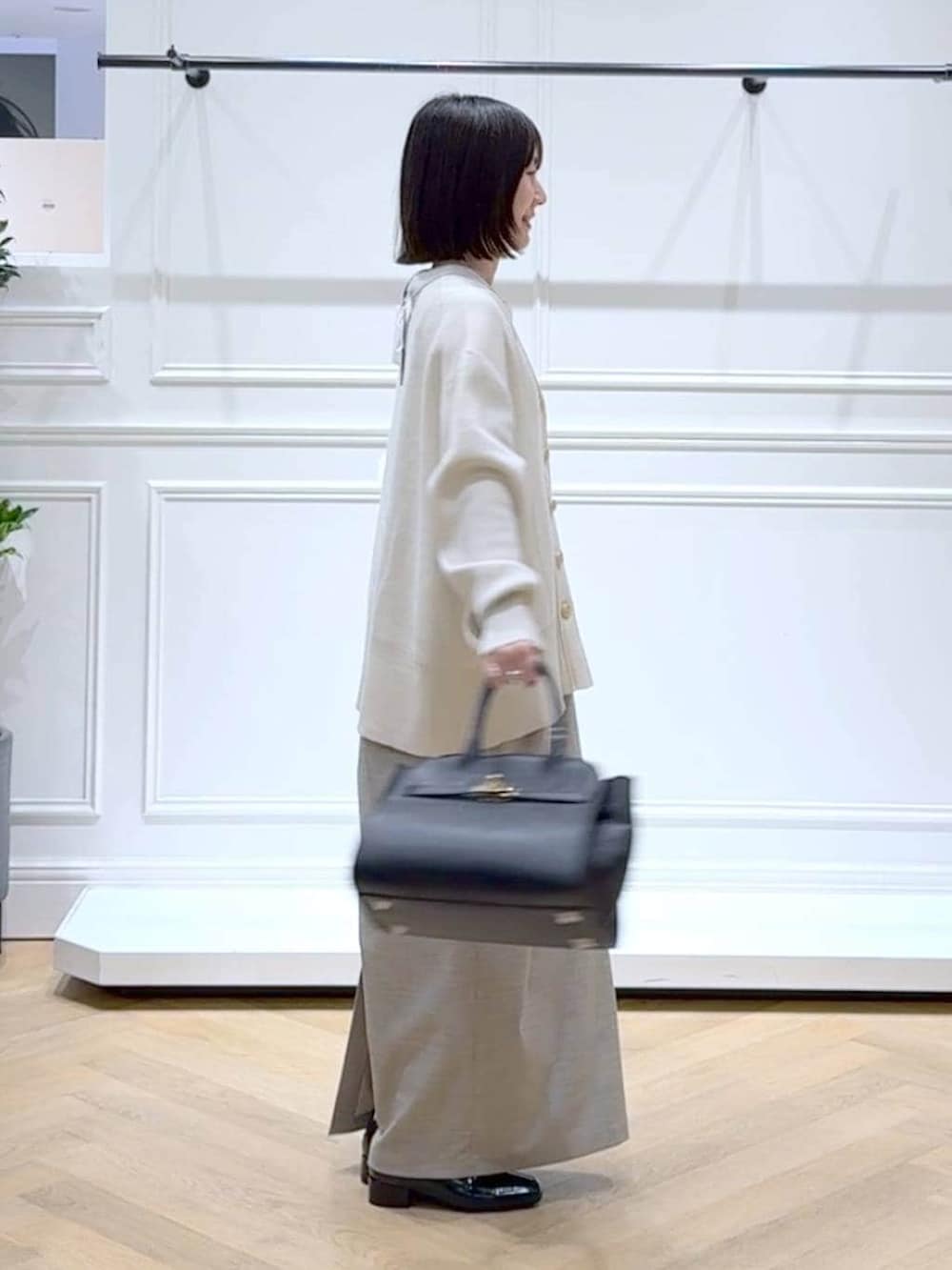 ブラック系のローファー、ホワイト系のカーディガン/ボレロ、ホワイト系のTシャツ/カットソーを着用したレディースの春コーディネートの3枚目の写真