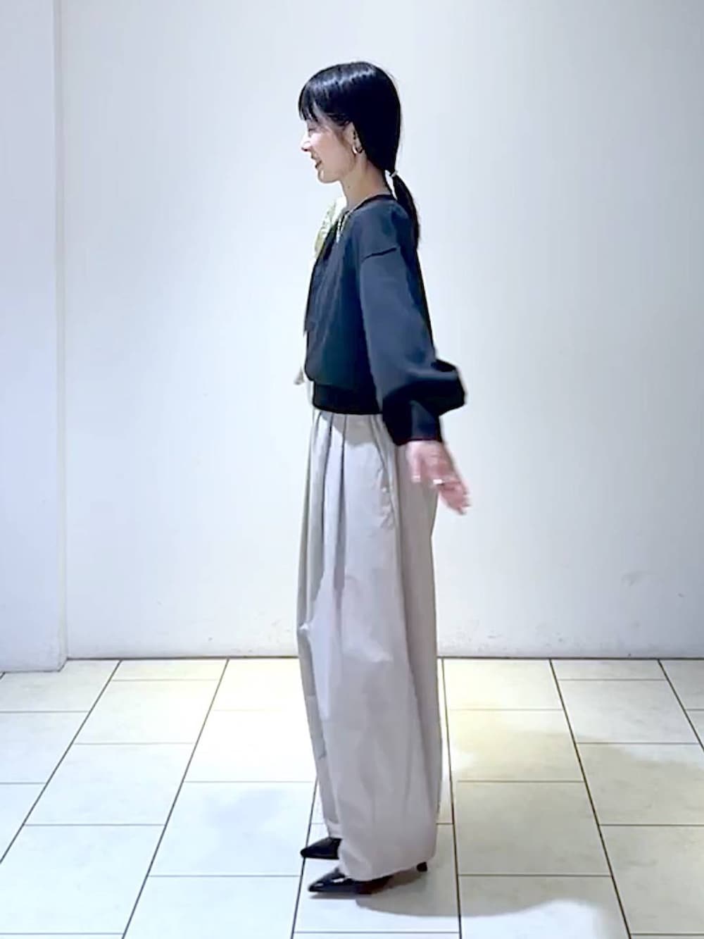 ブラック系のニット/セーター、ブラック系のパンプス、ホワイト系のショルダーバッグを着用したレディースの秋コーディネートの5枚目の写真