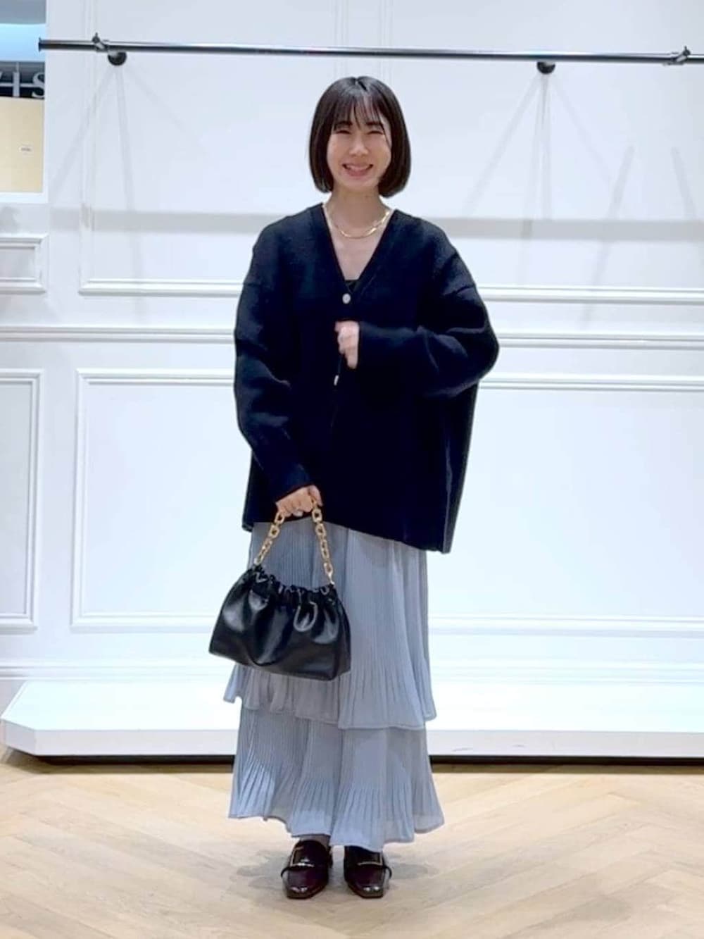 ブルー系のスカート、ブルー系のカーディガン/ボレロ、ブラック系のショルダーバッグを着用したレディースの春コーディネートの6枚目の写真