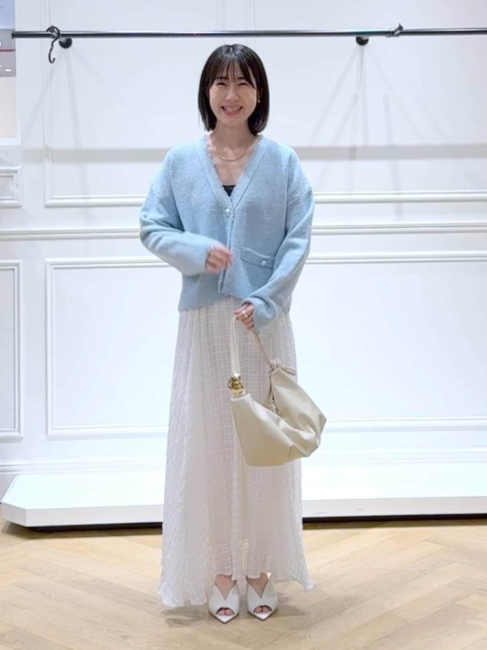 ブルー系のカーディガン/ボレロ、ホワイト系のサンダル、ホワイト系のスカートを着用したレディースの春コーディネートの6枚目の写真