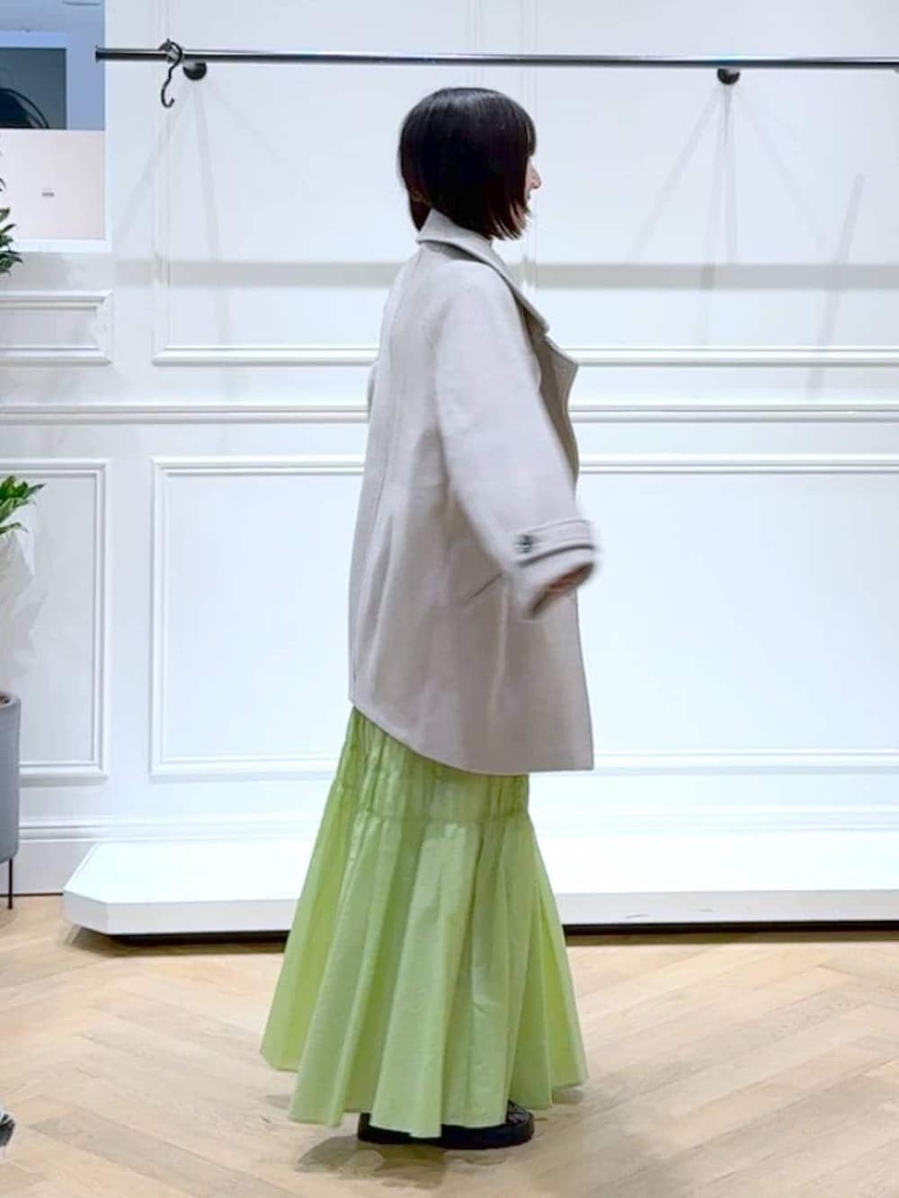 ベージュ系のピーコート、ホワイト系のニット/セーター、ブラウン系のローファーを着用したレディースの冬コーディネートの3枚目の写真