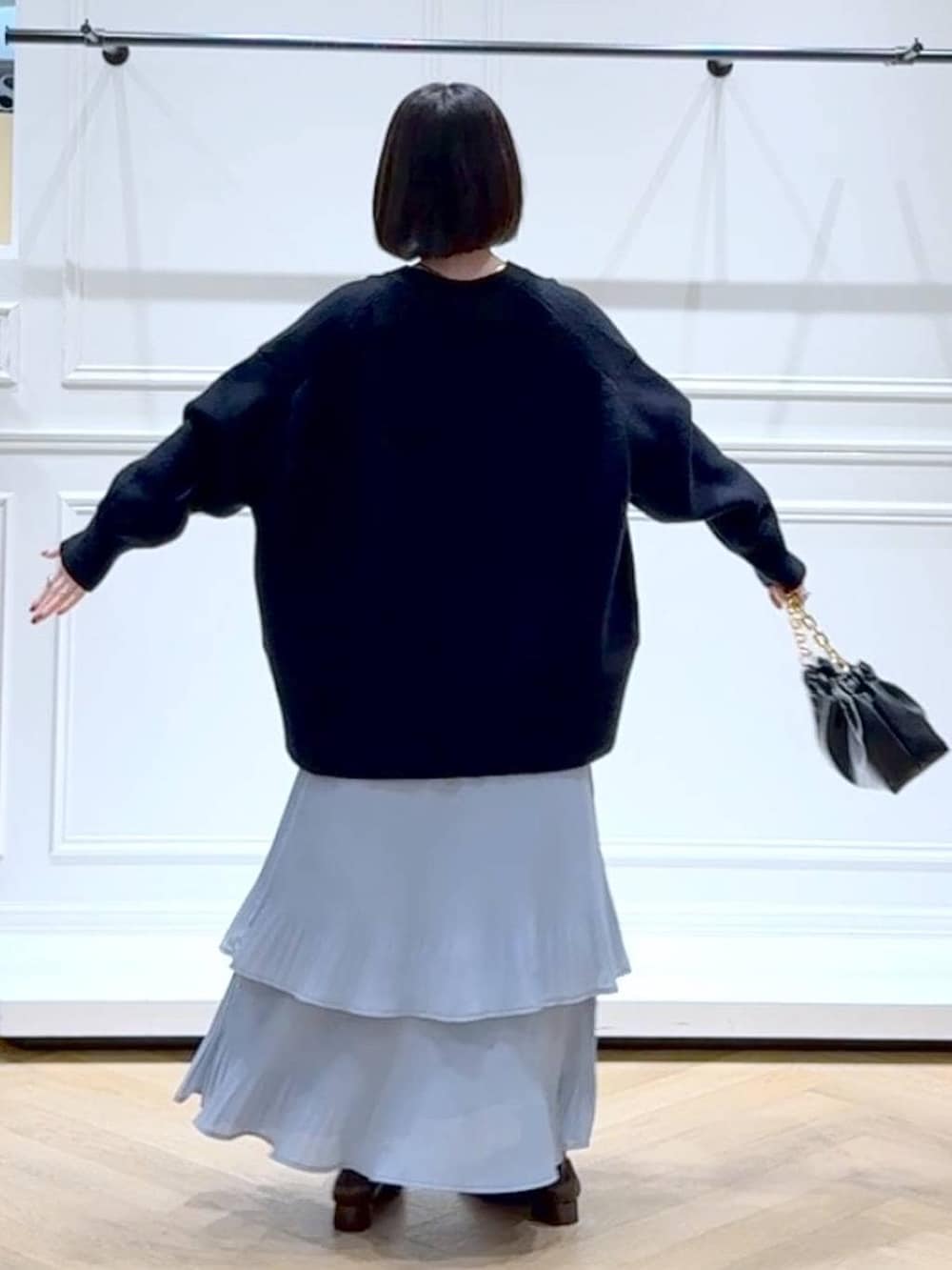 ブルー系のスカート、ブルー系のカーディガン/ボレロ、ブラック系のショルダーバッグを着用したレディースの春コーディネートの4枚目の写真