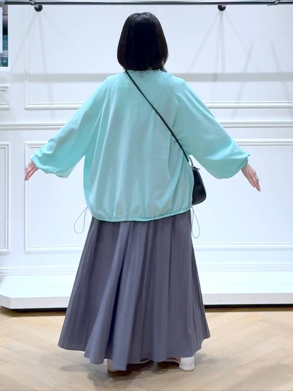 グリーン系のカーディガン/ボレロ、ホワイト系のサンダル、ホワイト系のTシャツ/カットソーを着用したレディースの夏コーディネートの4枚目の写真