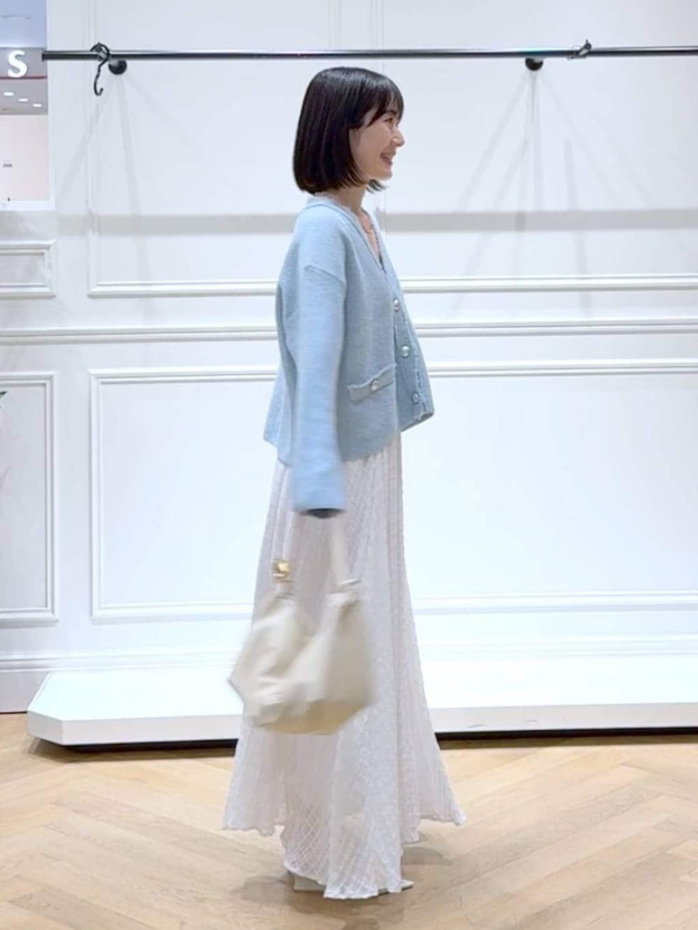 ブルー系のカーディガン/ボレロ、ホワイト系のサンダル、ホワイト系のスカートを着用したレディースの春コーディネートの3枚目の写真