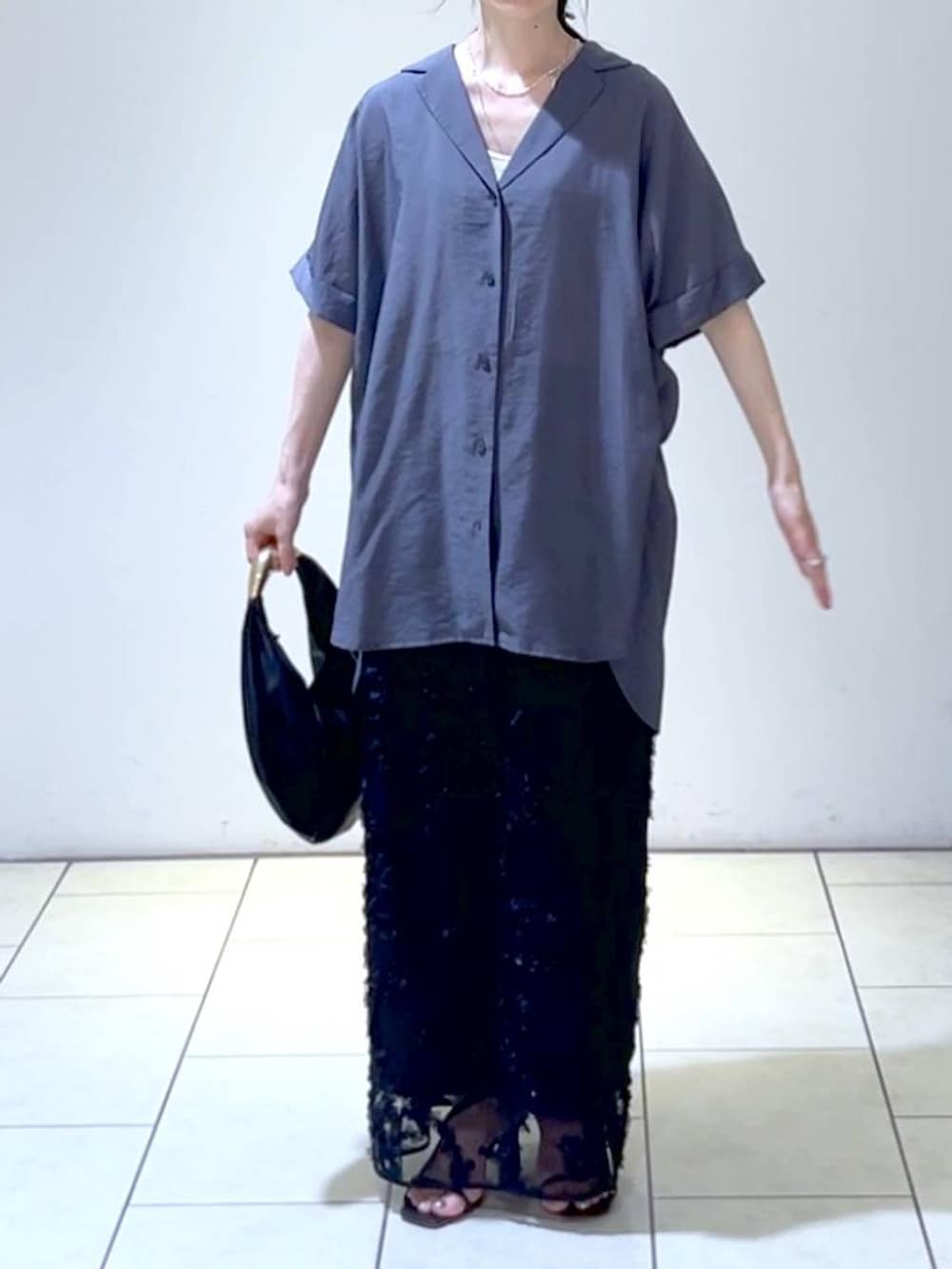 ブラック系のハンドバッグ、グレー系のシャツ/ブラウス、ブラック系のスカートを着用したレディースの夏コーディネートの2枚目の写真