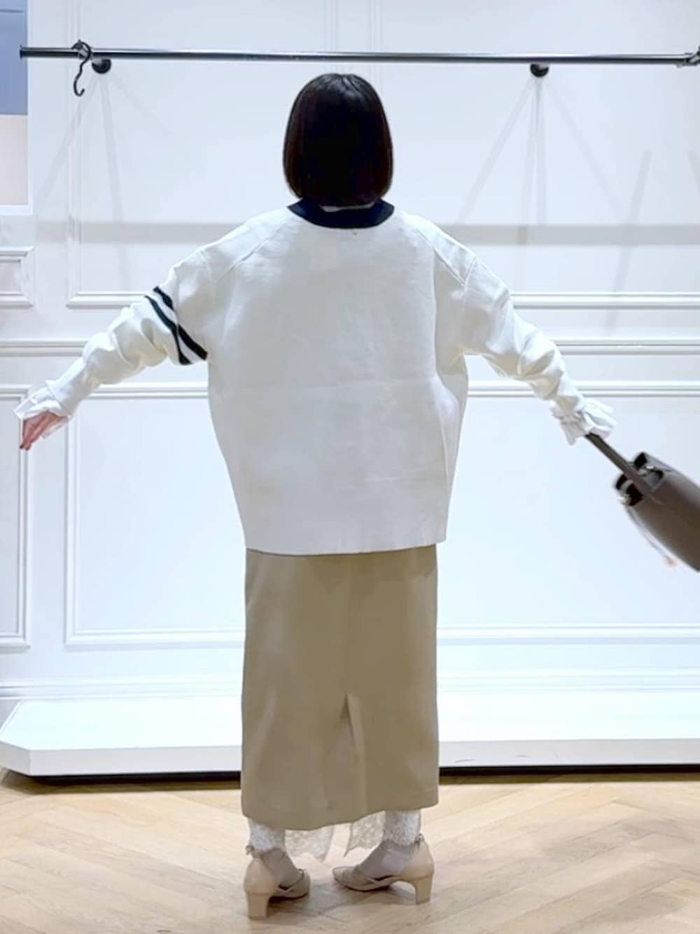 ブラック系のカーディガン/ボレロ、ベージュ系のスカート、ブラウン系のショルダーバッグを着用したレディースの春コーディネートの4枚目の写真