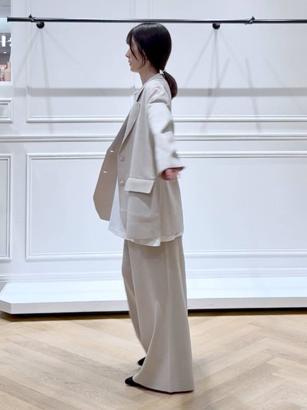 ベージュ系のパンツドレス、ブラック系のブーツ、ホワイト系のTシャツ/カットソーを着用したレディースの秋コーディネートの5枚目の写真