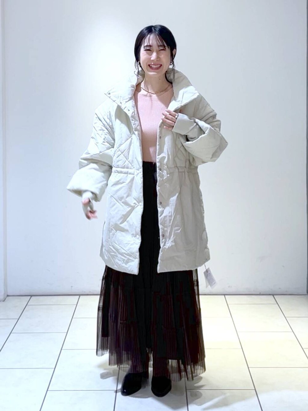 ピンク系のニット/セーター、ホワイト系のダウンジャケット/コート、ブラウン系のスカートを着用したレディースの冬コーディネートの5枚目の写真