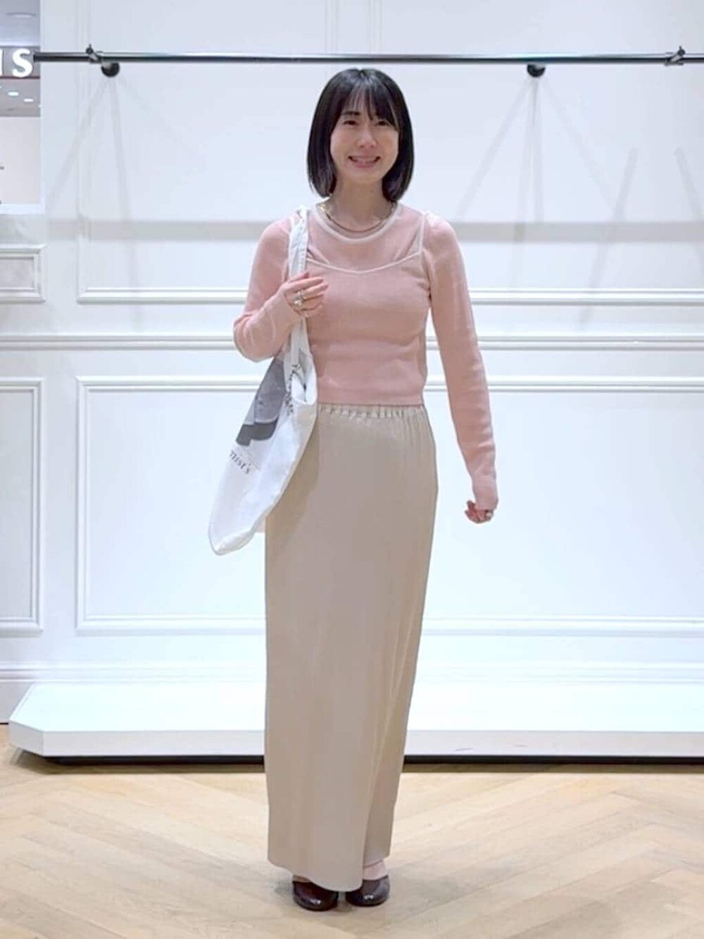 ホワイト系のスカート、ピンク系のTシャツ/カットソー、レッド系のパンプスを着用したレディースの春コーディネートの6枚目の写真