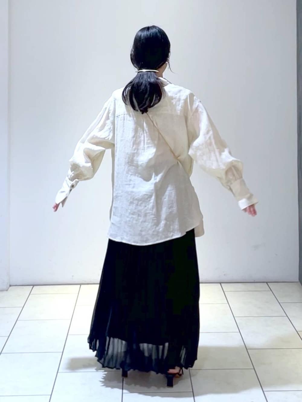 ベージュ系のシャツ/ブラウス、ブラック系のスカート、ホワイト系のショルダーバッグを着用したレディースの夏コーディネートの4枚目の写真