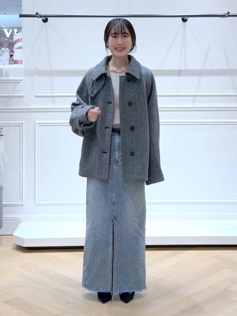 ホワイト系のニット/セーター、ブルー系のデニムスカート、ブラック系のブーツを着用したレディースの秋コーディネートの6枚目の写真