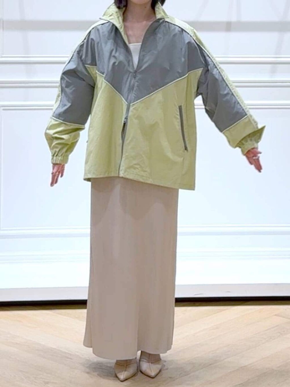 ホワイト系のスカート、イエロー系のブルゾン、ホワイト系のニット/セーターを着用したレディースの春コーディネートの2枚目の写真