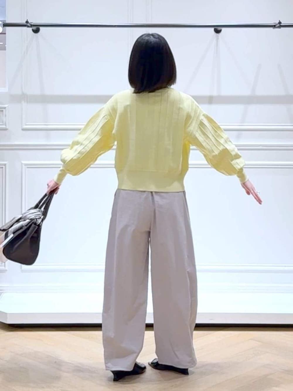 イエロー系のカーディガン/ボレロ、ブラウン系のショルダーバッグ、ブラック系のサンダルを着用したレディースの春コーディネートの4枚目の写真