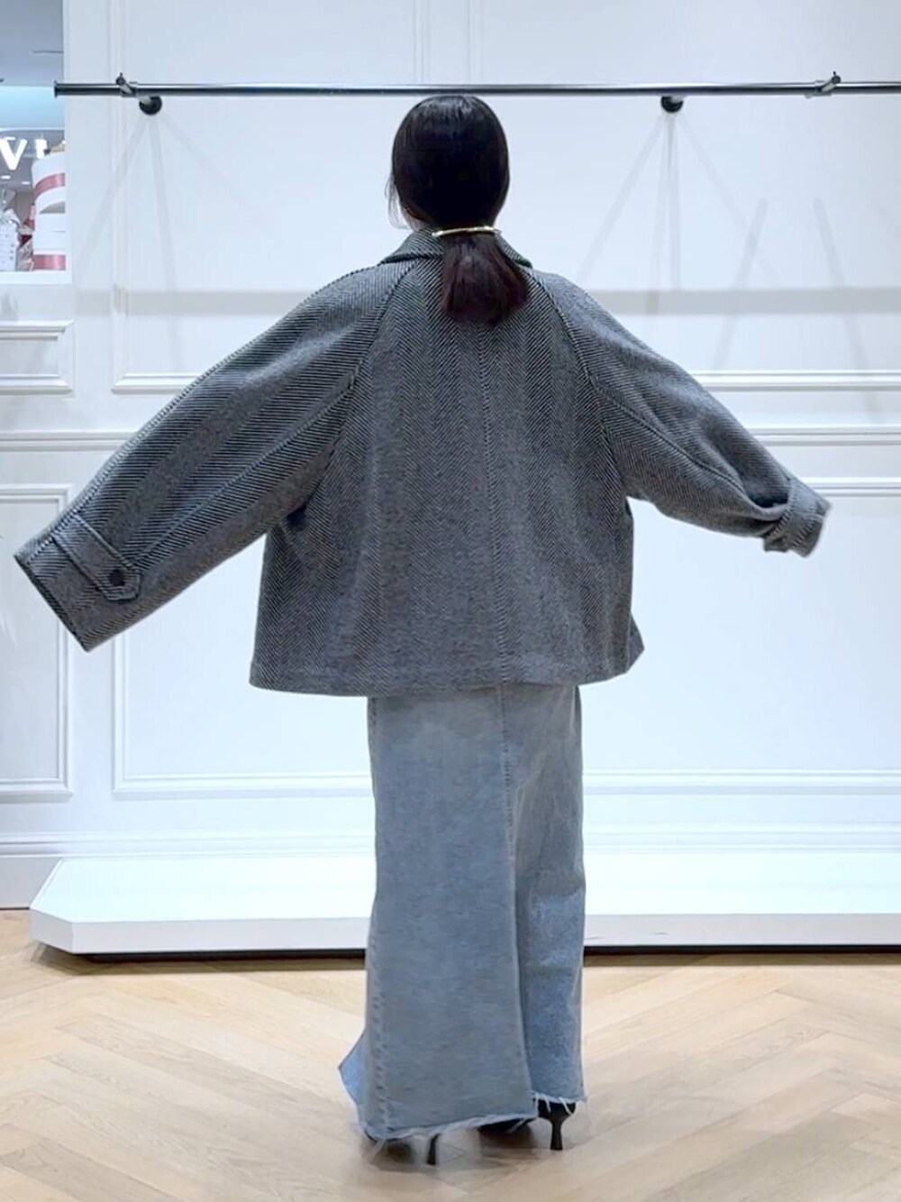 ホワイト系のニット/セーター、ブルー系のデニムスカート、ブラック系のブーツを着用したレディースの秋コーディネートの4枚目の写真