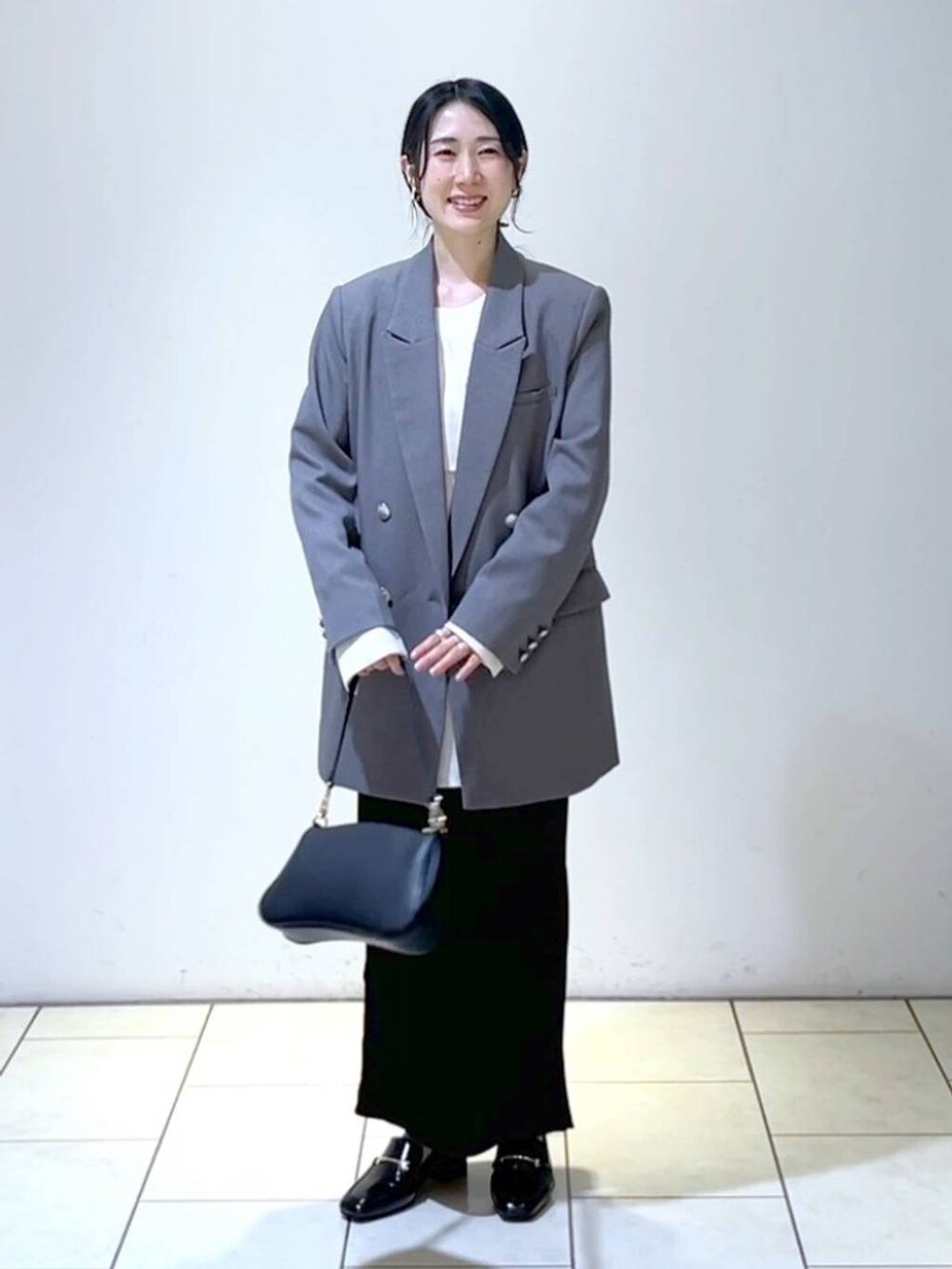 ホワイト系のシャツ/ブラウス、ブラック系のローファー、ブラック系のショルダーバッグを着用したレディースの春コーディネートの5枚目の写真