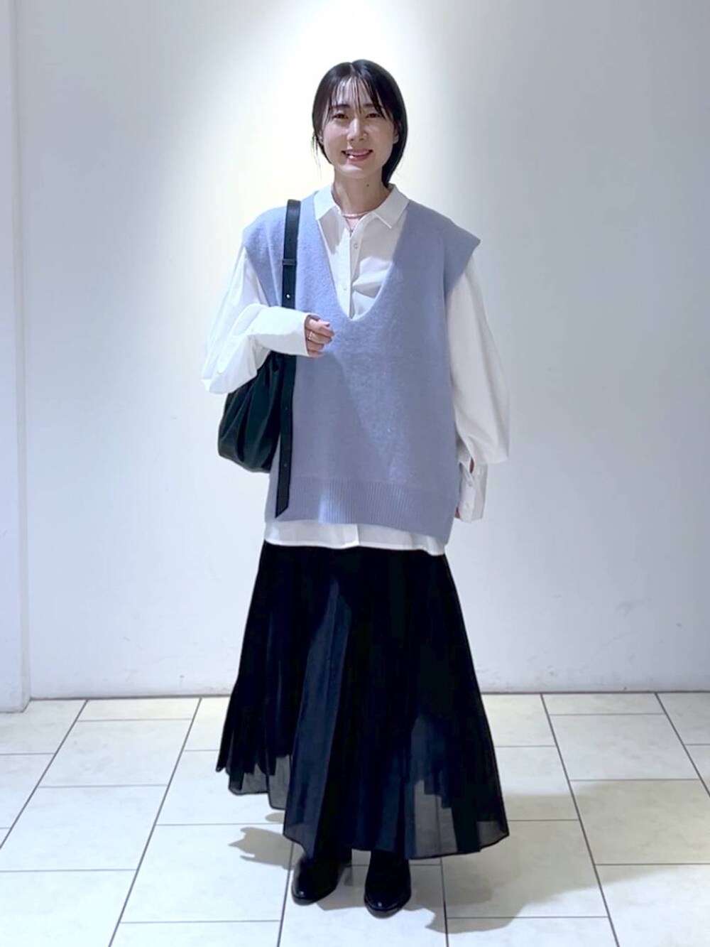 ホワイト系のシャツ/ブラウス、ブラック系のブーツ、ブラック系のスカートを着用したレディースの秋コーディネートの5枚目の写真