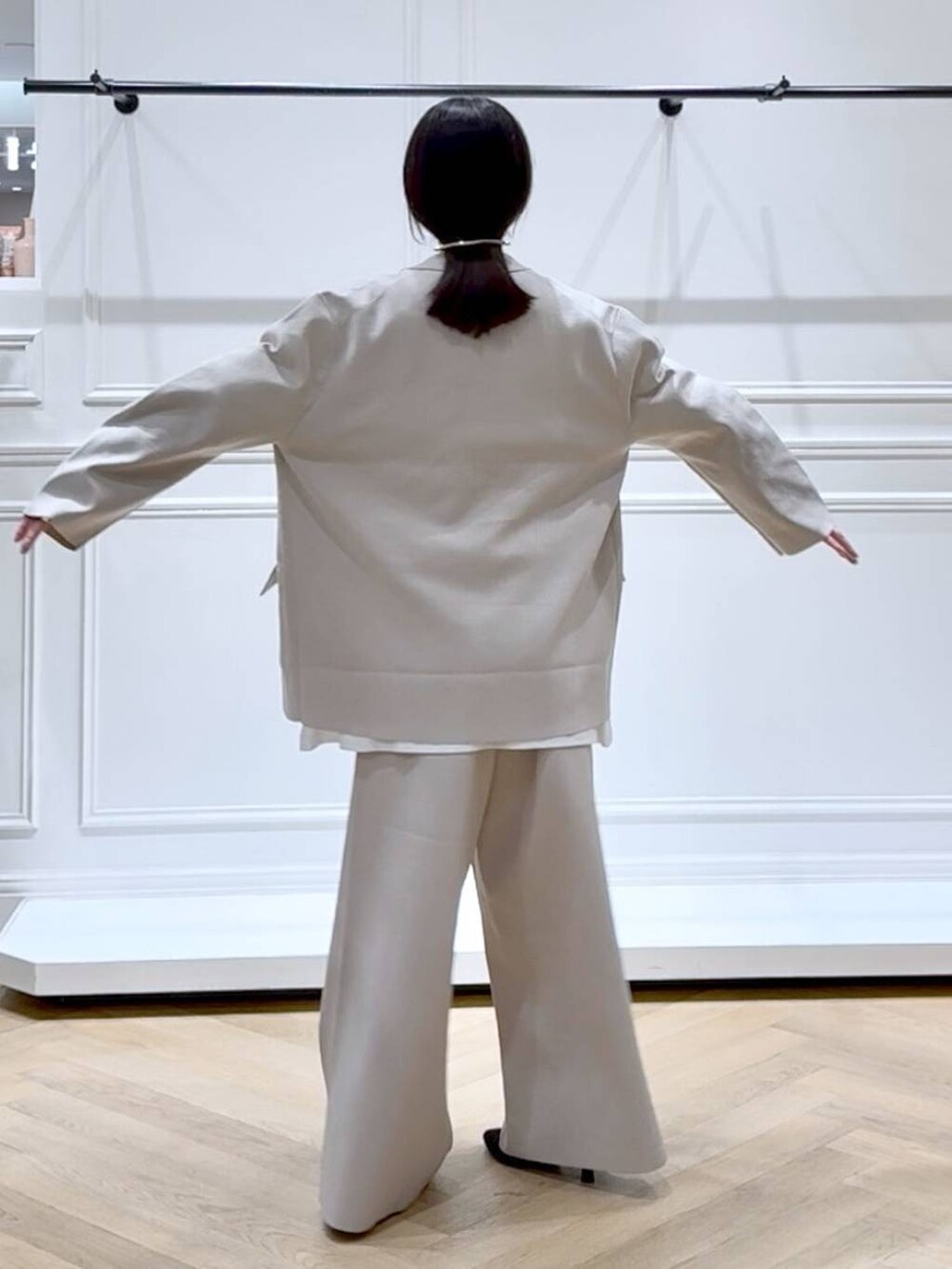 ベージュ系のパンツドレス、ブラック系のブーツ、ホワイト系のTシャツ/カットソーを着用したレディースの秋コーディネートの4枚目の写真